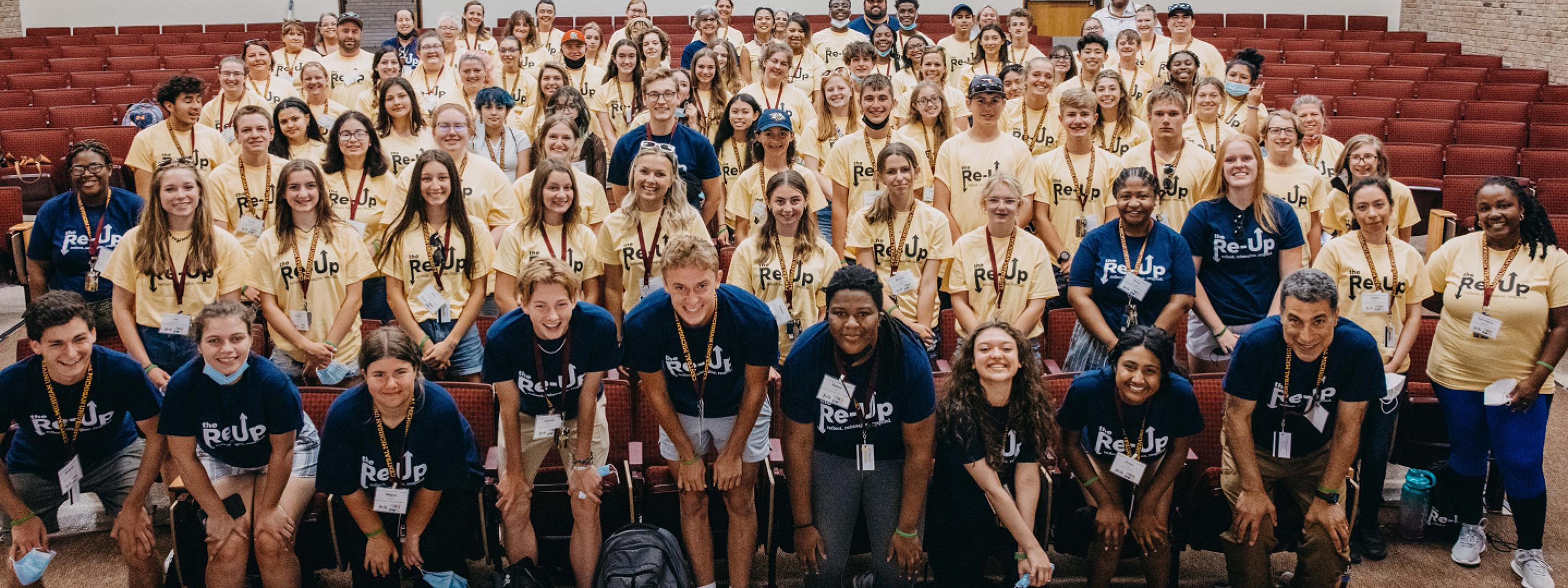 Group photo of attendees of 2022 Youth Conference in a large auditorium style room