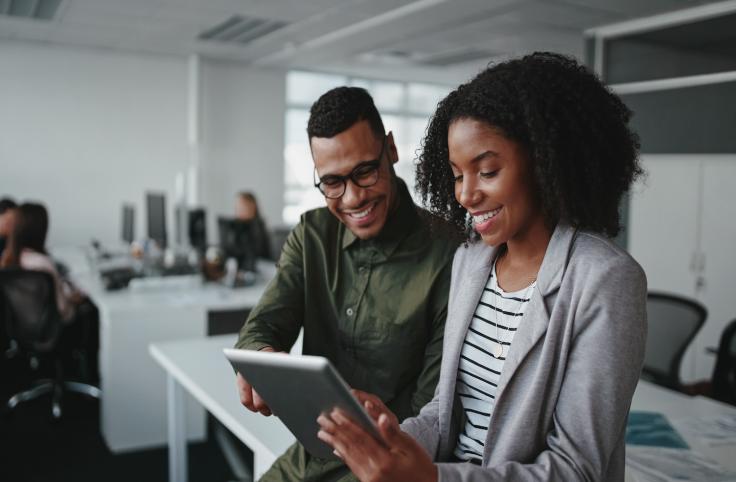 Two people smiling looking at a document