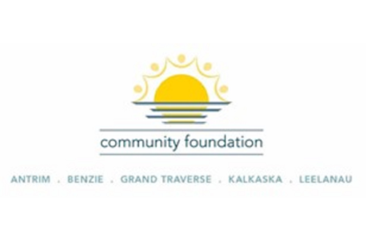 Grand Traverse Regional Community Foundation Logo with a sun like image rising from and reflecting on a water horizon