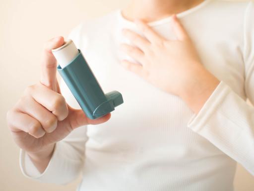 Child holding an asthma inhaler.