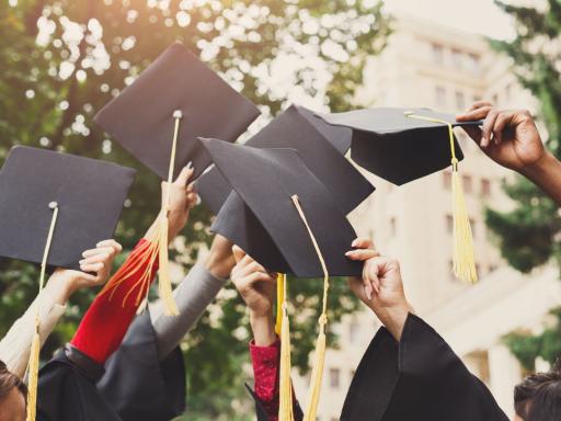 graduates holding their caps.