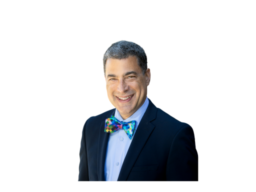 Kyle is smiling at the camera wearing a suit and a bow tie.