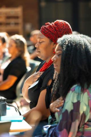 Two women practicing wellness through meditation. 
