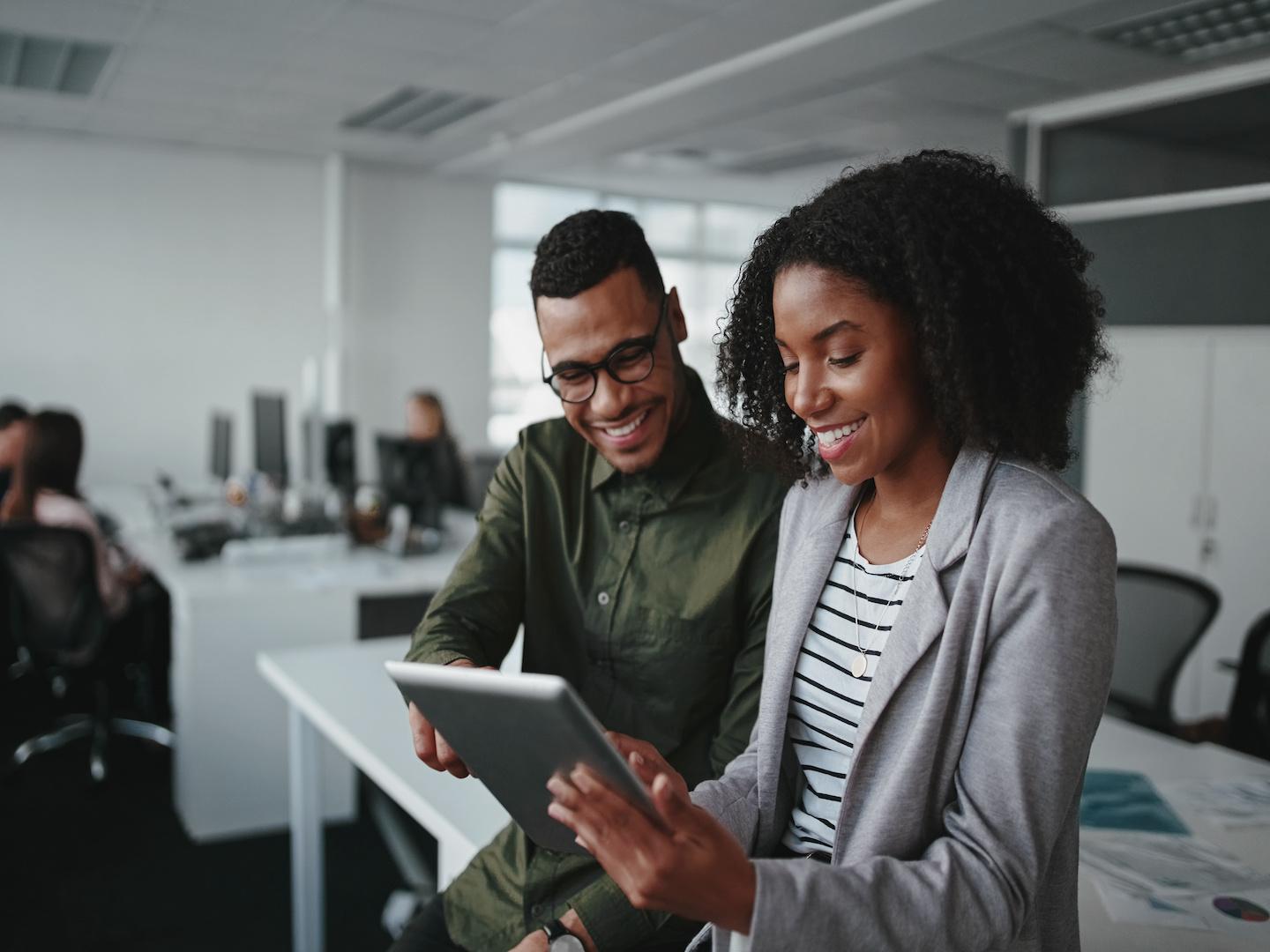 Two people smiling looking at a document