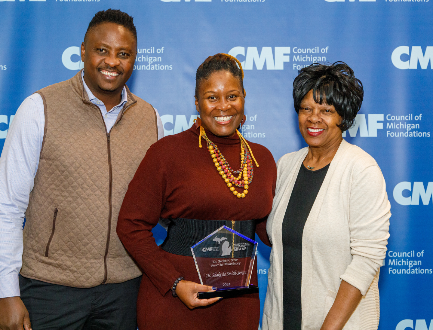 Posed photo in front of our CMF banner after an award presentation with our award winner and her family