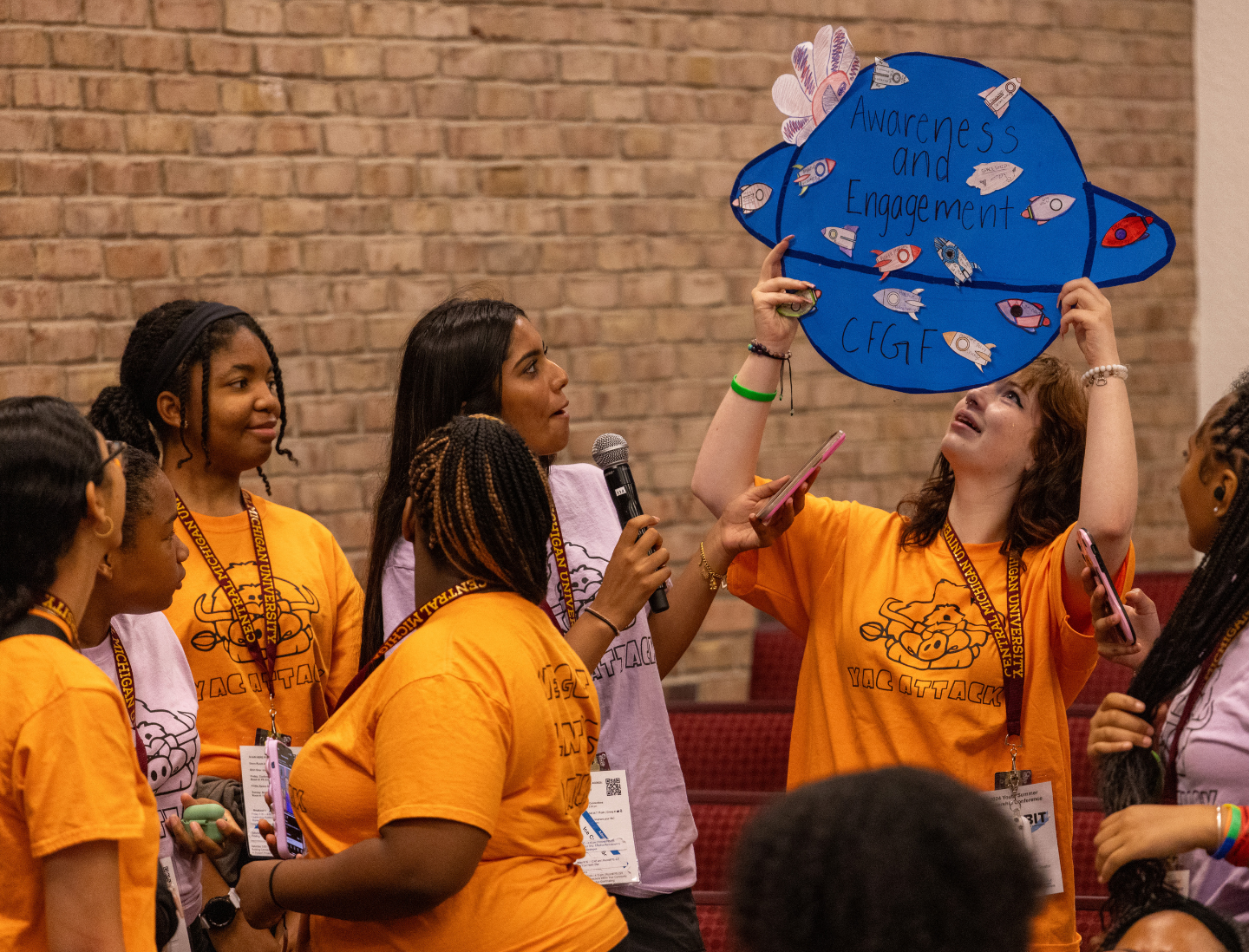 A group of participants in the youth programming present a project they created to represent themselves to the larger group