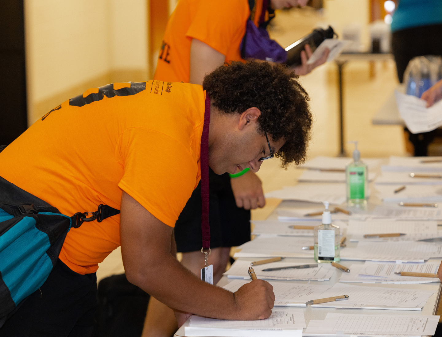 A participant in one of the youth programs signs in on a sheet of paper during one of the weekend long gatherings