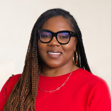 Khalilah Burt Gaston's headshot - she is wearing a red blouse and glasses, smiling at the camera