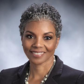 Headshot for Faye Alexander Nelson, wearing a black suit jacket and smiling at the camera
