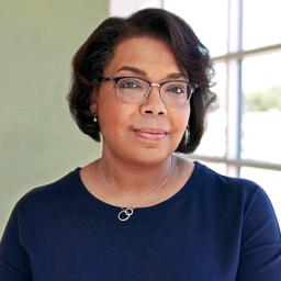 Aimee Laramore wearing glasses with a dark blue sweater.
