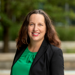 Photo of Andrea Judd-Shurmur, wearing a green blouse with a black suit jacket, smiling