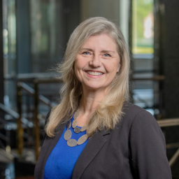 Professional Headshot of Julie Morse wearing a blue shirt and black blazer smiling at the camera