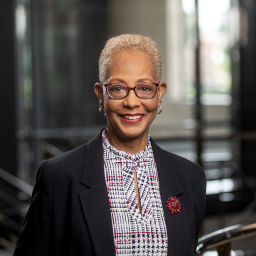 Headshot of Karen Aldridge-Eason, wearing a patterned shirt under a dark blue suit jacket, smiling