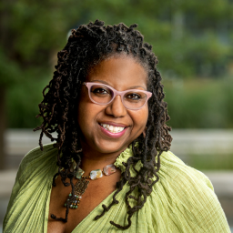 Headshot of Regina Bell in a light green blouse, with a necklace and glasses, smiling