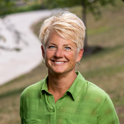 Headshot of Sue Cuddington in a green collared blouse, smiling